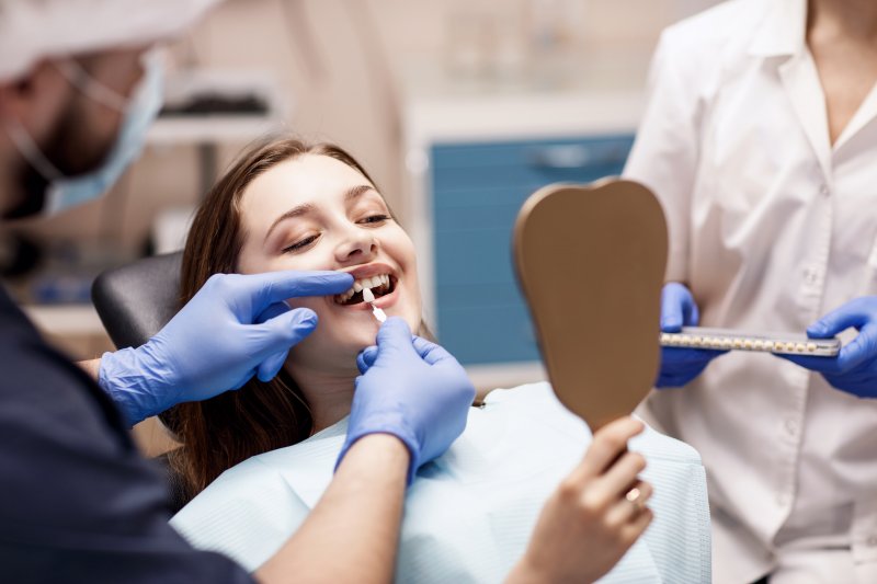 A dentist preparing a woman for cosmetic dentistry